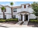 Charming townhome exterior boasts a well-maintained facade, tiled roof, and verdant landscaping at 1578 Slice Way, Davenport, FL 33896