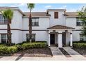 Townhome exterior featuring white facade, brown trim, tiled roof and manicured landscaping at 1578 Slice Way, Davenport, FL 33896