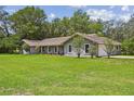 Beautiful single story home with large front lawn, mature trees, and attached side-entry garage at 16 Pine Forest Dr, Haines City, FL 33844