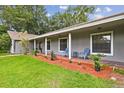 Inviting front porch with brick flooring, rocking chairs, and fresh landscaping at 16 Pine Forest Dr, Haines City, FL 33844