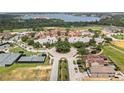 Aerial view of the community featuring a village center with tennis courts and meticulously kept grounds at 16049 Volterra Pt, Bella Collina, FL 34756