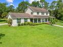 Attractive two-story home with a large front yard, manicured hedges, and a welcoming covered porch at 2471 Jenscot Rd, St Cloud, FL 34771