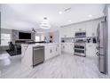 Modern kitchen with stainless steel appliances, a kitchen island, and sleek white cabinetry at 2503 Calla Lily Cv, Kissimmee, FL 34758