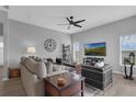 Bright living room with gray walls, neutral furniture, ceiling fan and views of the outdoors at 3617 Northwoods Dr, Kissimmee, FL 34746