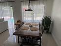 Sunlit dining area with view of the pool, features modern light fixture and seating for six at 416 Sea Willow Dr, Kissimmee, FL 34743