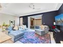 Bright living room features a comfortable blue sofa, plush rug, and sliding glass doors to the outside at 5103 Jones Rd, St Cloud, FL 34771
