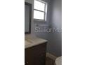 Conveniently located powder room showcasing a vanity with sink and a window for natural light at 5144 Picadilly Circus Ct # 2, Orlando, FL 32839