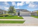 Charming two-story home featuring a lush lawn, inviting entrance, and convenient two-car garage at 5225 Tuscany Ln, Davenport, FL 33897