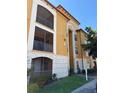 Three-story condo building showcasing screened lanais, tan and white exterior, and well-maintained landscaping at 6169 Metrowest Blvd # 208, Orlando, FL 32835
