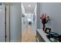 Long hallway features beige-tiled flooring, neutral-colored walls, and minimal decorations at 6834 Habitat Dr, Harmony, FL 34773