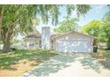 Single-story home with a large front lawn, two-car garage, and traditional architectural details at 7410 Orange Crest Cir, Lakeland, FL 33810