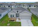 Inviting single-Gathering home featuring a well-maintained lawn, attached two-car garage, and covered entryway at 757 Citrus Reserve Blvd, Davenport, FL 33837