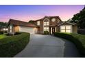 Charming two-story home with an attached garage and a neatly landscaped circular driveway at 7846 Snowberry Cir, Orlando, FL 32819