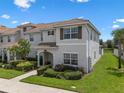 Beautifully landscaped two-story home with tiled roof and well-maintained lawn at 8947 Stinger Dr, Davenport, FL 33896