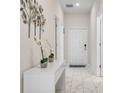Bright hallway features marble tiled floors, white walls, and modern decor at 8947 Stinger Dr, Davenport, FL 33896