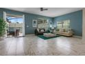 Spacious living room with marble floors, bright windows, and modern furniture at 8947 Stinger Dr, Davenport, FL 33896