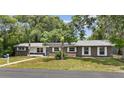 Well-maintained single-story home with lush landscaping and a spacious front yard, complete with solar panels at 1800 Banyan St, Orange City, FL 32763