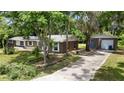Exterior view of the home with lush greenery and a detached garage at 1800 Banyan St, Orange City, FL 32763
