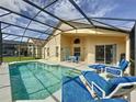 Enclosed pool area with a screen enclosure, lounge chairs, and outdoor dining set at 2649 Hemingway Ave, Haines City, FL 33844