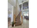 Carpeted staircase with wooden handrails leads to the second floor, with views of the dining and living areas at 2735 Scarborough Dr, Kissimmee, FL 34744
