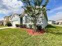 Side view of the home featuring lush lawn and landscaping, nestled in a quiet neighborhood at 2839 Harmonia Hammock Rd, Harmony, FL 34773