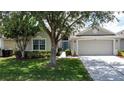 Charming home featuring a well-maintained lawn, mature trees, and a two-car garage at 2924 White Cedar Cir, Kissimmee, FL 34741