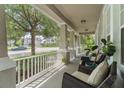 Inviting covered front porch with comfortable seating area, perfect for relaxing and enjoying the neighborhood views at 3310 Cat Brier Trl, Harmony, FL 34773