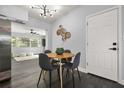Modern dining area featuring stylish lighting, a round table, and adjacent views to a living area at 410 Kentia Rd, Casselberry, FL 32707
