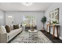 Inviting living room with a neutral palette, large window, and comfortable seating arrangement at 410 Kentia Rd, Casselberry, FL 32707