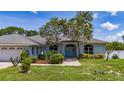 Attractive single-story home featuring an arched entryway, neat landscaping, and healthy trees at 415 Smiley Ct, Winter Haven, FL 33884
