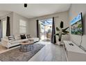Bright living room features a large sliding door to the outdoor patio, tile floors, modern furniture and décor at 4981 Windermere Ave, Kissimmee, FL 34746