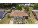 Aerial view of a home with a shingled roof, a well-kept yard, and surrounding mature trees at 505 Oak Dr, Tavares, FL 32778