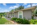 Side view of a cozy single-story home with well-maintained landscaping, and a welcoming front porch at 505 Oak Dr, Tavares, FL 32778