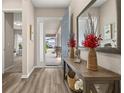 Elegant foyer with hardwood floors, decorative console table, mirror, and a view of the front porch at 5133 Citrus Leaf Blvd, Winter Garden, FL 34787