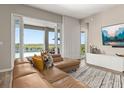 Bright living room featuring a comfortable leather sofa, large sliding glass doors, and a view of the pool at 5133 Citrus Leaf Blvd, Winter Garden, FL 34787