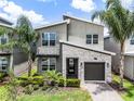 A charming two-story house with a modern design, beautiful stonework, and lovely landscaping at 661 Drop Shot Dr, Davenport, FL 33896