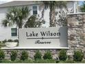 Landscaped entrance sign for Lake Wilson Reserve, accented by palm trees at 7717 Stone Creek Trl, Kissimmee, FL 34747