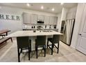 Modern kitchen with gray cabinets, stainless steel appliances, and a quartz countertop island at 775 Longboat Dr, Davenport, FL 33896