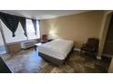Bedroom featuring a comfortable bed, window, and simple furnishings at 7900 S Orange Blossom Trl # 2074, Orlando, FL 32809