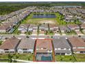 Gorgeous aerial view showcasing the home's pool and proximity to a community pond at 9071 Woodland Forest Rd, Orlando, FL 32836