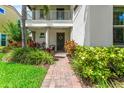 Inviting front entrance with brick pathway, lush plants, and a cozy seating area at 10067 Mere Pkwy, Orlando, FL 32832