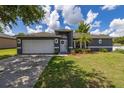 Single-story home featuring a well-manicured lawn, mature trees, and attractive landscaping at 138 Hidden Pointe Ln, Groveland, FL 34736