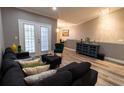 Comfortable living room with a black sectional, stylish decor, and ample natural light, perfect for relaxation at 14205 Falls Church Dr # 2012, Orlando, FL 32837