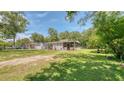 Single-story home with a well-maintained lawn, mature shade trees, and inviting porch seating at 1431 Jack Calhoun Dr, Kissimmee, FL 34741