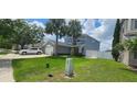 Two-story home featuring a two car garage, palm tree, and manicured front yard at 1827 Meadow Pond Way, Orlando, FL 32824