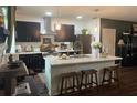 Modern kitchen featuring dark cabinets, stainless steel appliances, and a center island at 1868 Katz Crossing Dr, Kissimmee, FL 34744