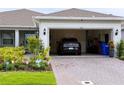View into the two-car garage, highlighting the interior space and access from the driveway, including an electric car at 1875 Spring Shower Cir, Kissimmee, FL 34744