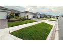 A street view showcasing the well-maintained lawns and similar architectural design of the neighborhood homes at 1875 Spring Shower Cir, Kissimmee, FL 34744