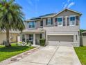 Charming two-story home with well-maintained landscaping, a palm tree, a covered porch and a two car garage at 209 Willow Bend Dr, Davenport, FL 33897