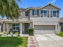 Charming two-story home with well-maintained landscaping, a palm tree, a covered porch and a two car garage at 209 Willow Bend Dr, Davenport, FL 33897